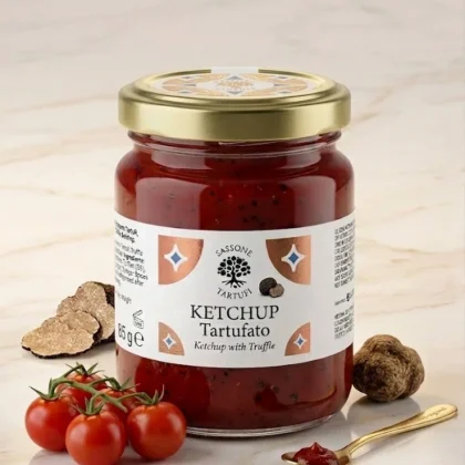 Słoiczek włoskiego ketchupu z truflą marki Sassone Tartufi, obok świeżych pomidorków koktajlowych i plastrów trufli.